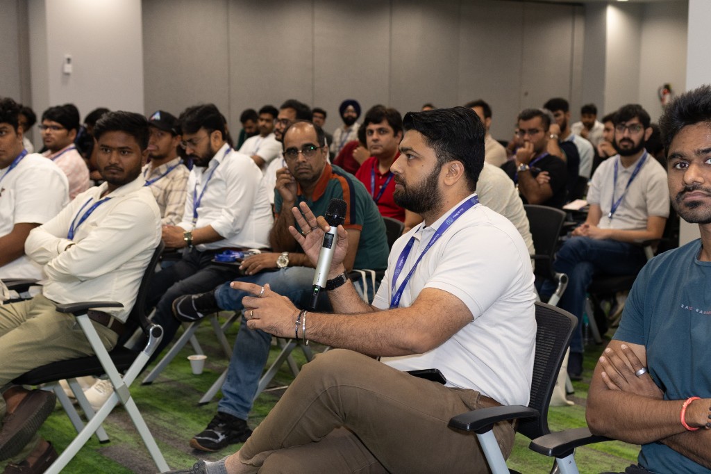 An engaged product manager in the audience asking a question with a mic at the ACE Delhi-Gurugram conference.